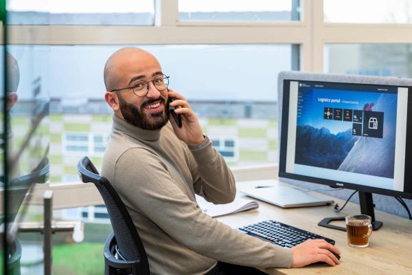 Collega aan het bellen achter computer